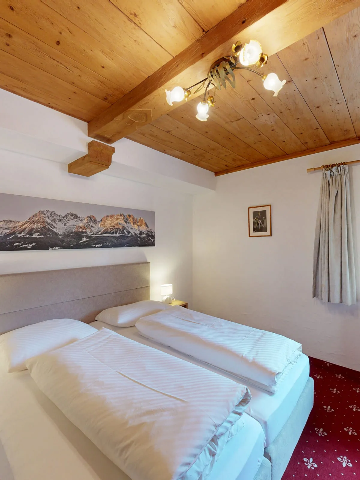 Helles Zimmer mit zwei Einzelbetten, Fenster und Holzbalkendecke