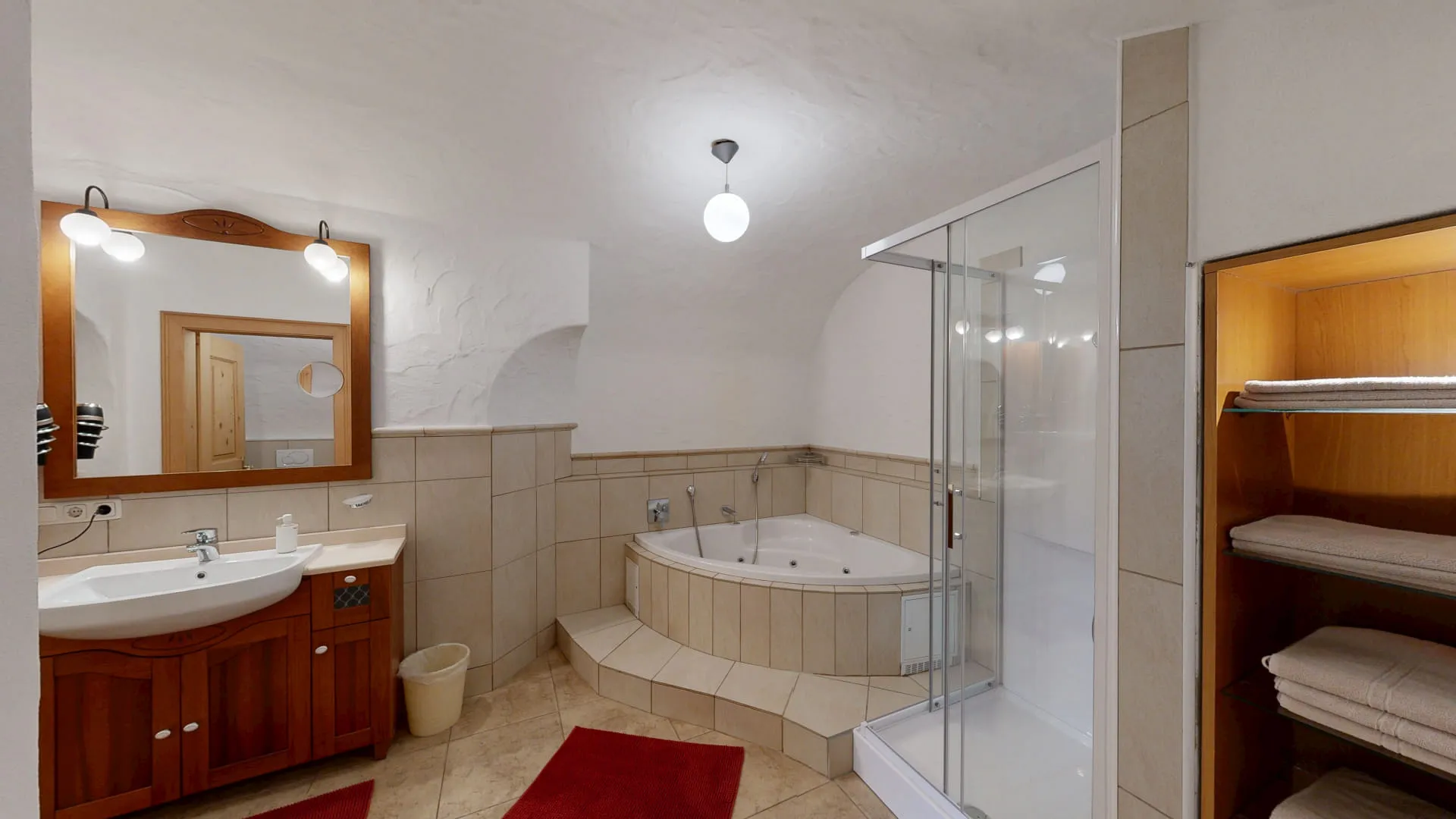 Badezimmer mit Wanne, Duschkabine und großen Spiegeln